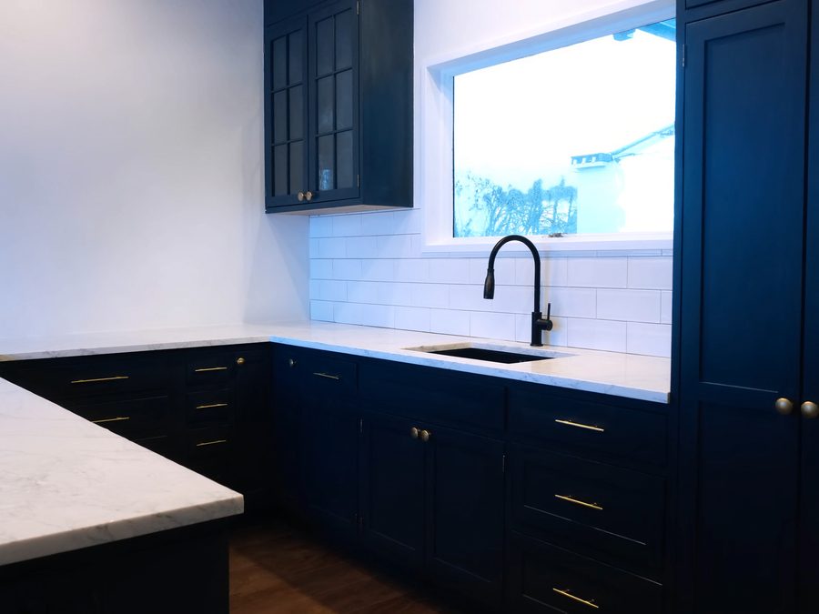 Kitchen with freshly painted navy cabinets and brass hardware